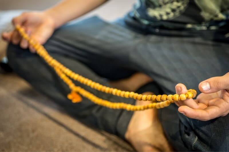 Yoga-Philosophie | Mann meditiert mit Japa Mala