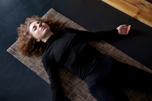 Einschlafen üben in der Shavasana Position Bild einer Frau, die Shavasana übt